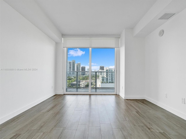 empty room with wood-type flooring and floor to ceiling windows