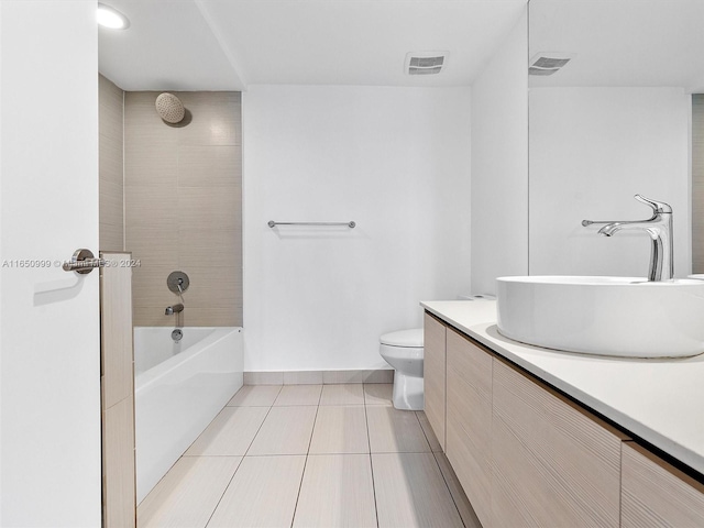 full bathroom with tile patterned floors, tiled shower / bath combo, vanity, and toilet