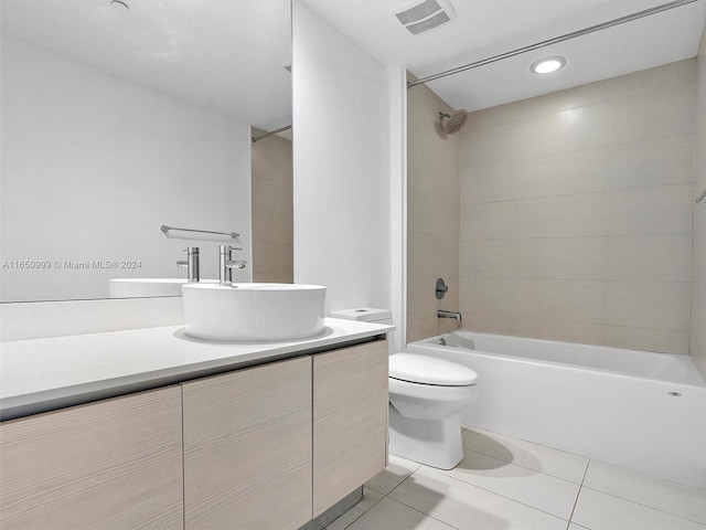 full bathroom featuring tile patterned flooring, tiled shower / bath, vanity, and toilet