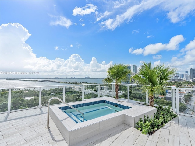 view of swimming pool featuring a water view and an in ground hot tub