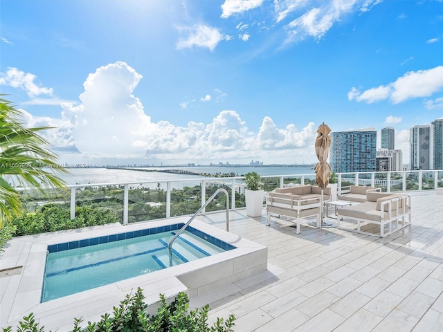 view of pool featuring a water view, outdoor lounge area, and an in ground hot tub