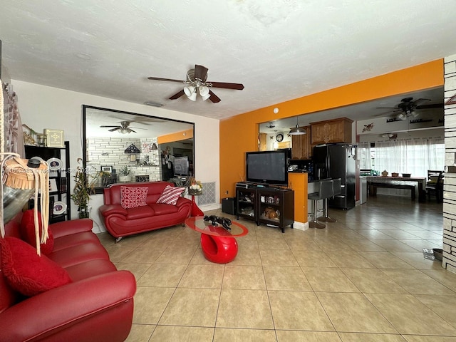 tiled living room featuring a textured ceiling and ceiling fan