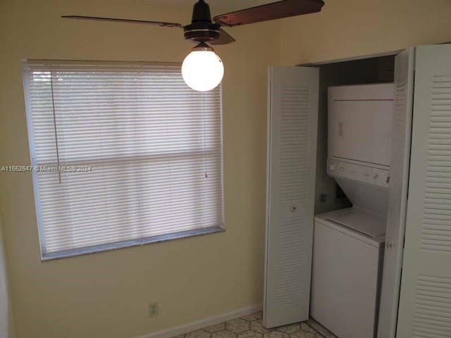 washroom with a wealth of natural light, ceiling fan, and stacked washing maching and dryer