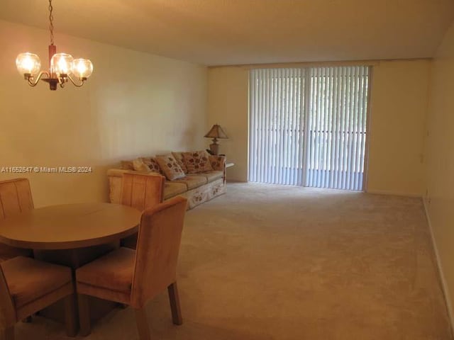 dining area with carpet flooring and a chandelier