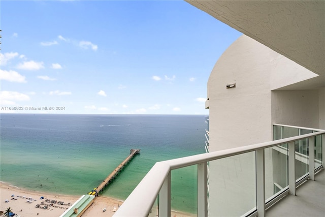 balcony featuring a beach view and a water view