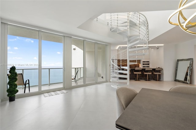 living room with floor to ceiling windows, a notable chandelier, and a water view