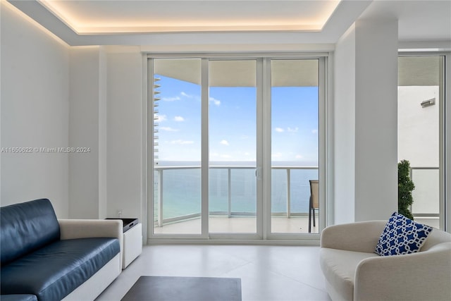 interior space featuring a tray ceiling and a water view