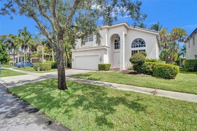 mediterranean / spanish-style house with a garage and a front yard