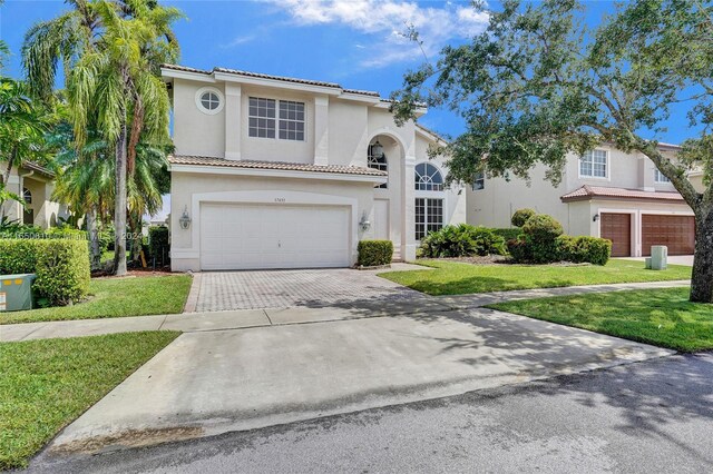 mediterranean / spanish home with a front yard and a garage