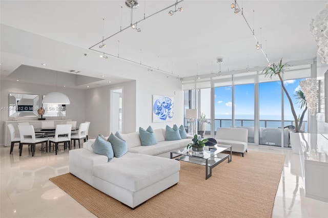 living area with expansive windows, a water view, visible vents, and recessed lighting