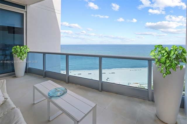 balcony featuring a water view and a beach view