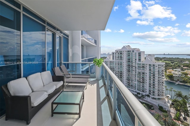 balcony with a water view, a view of city, and an outdoor hangout area