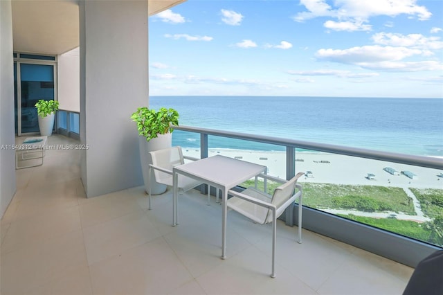 balcony with a water view and a view of the beach