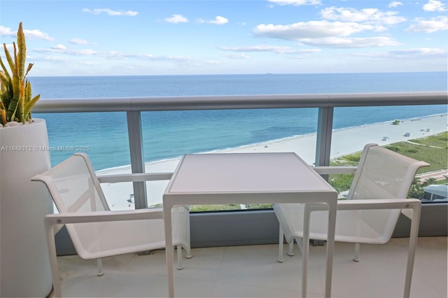 balcony with a water view and a view of the beach