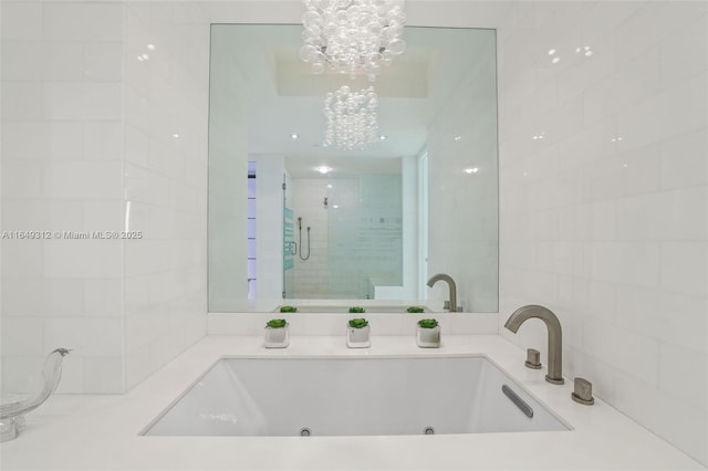 bathroom with a whirlpool tub, a stall shower, a chandelier, and tile walls