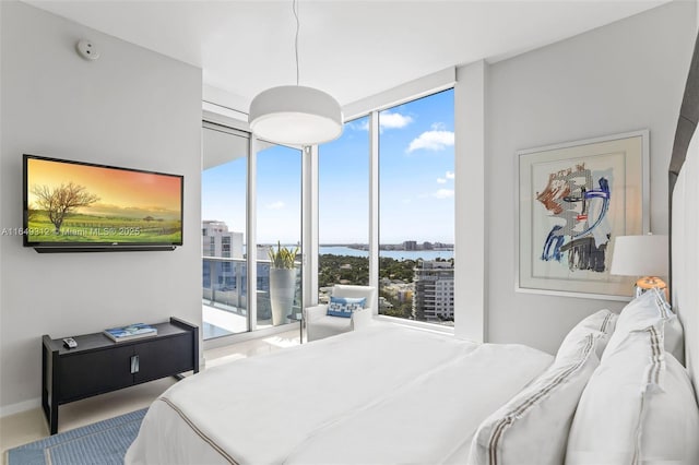 bedroom with expansive windows and a water view