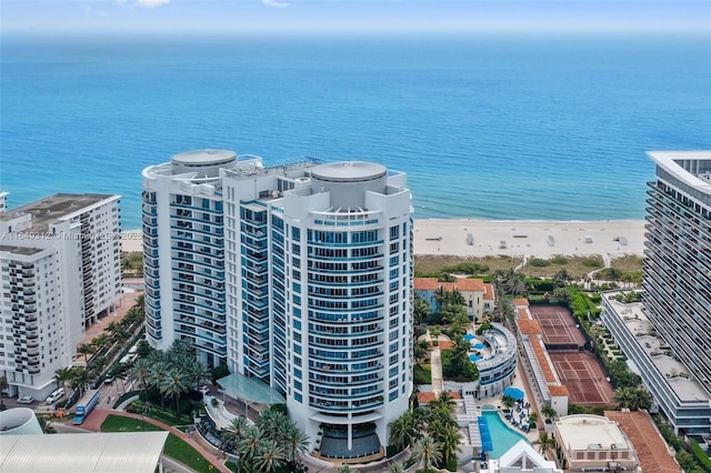 drone / aerial view featuring a water view, a beach view, and a city view