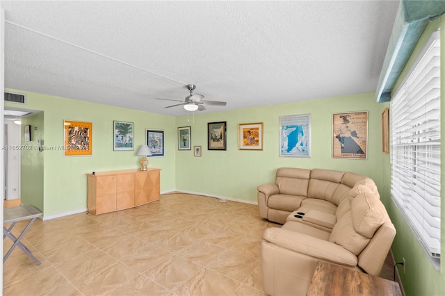 living room with ceiling fan and a textured ceiling