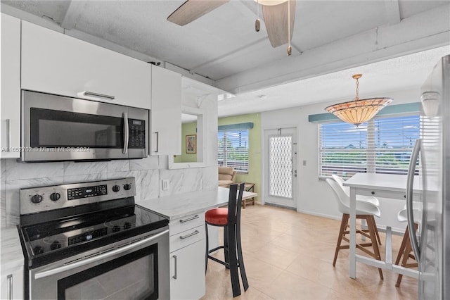 3024 Farnham O Unit 3024, Deerfield Beach, FL 33442 - kitchen with appliances with stainless steel finishes, white cabinets, light countertops, backsplash, and hanging light fixtures
