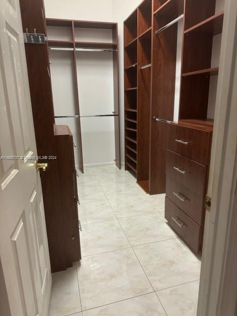 spacious closet featuring light tile patterned floors