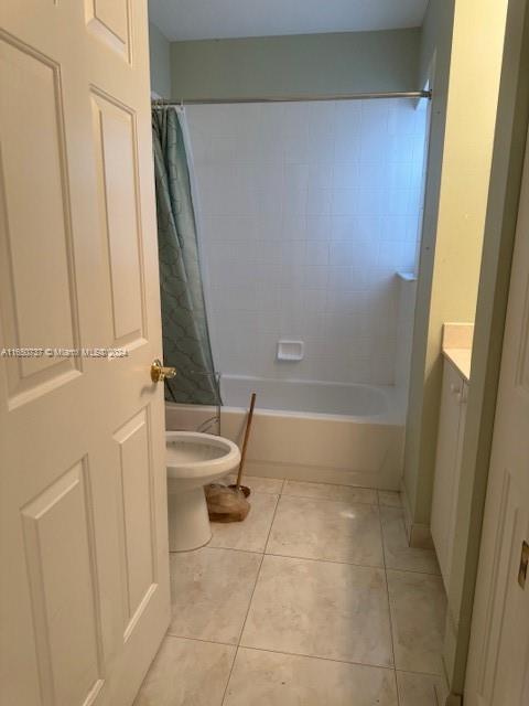 bathroom featuring tile patterned floors, shower / bath combination with curtain, toilet, and vanity