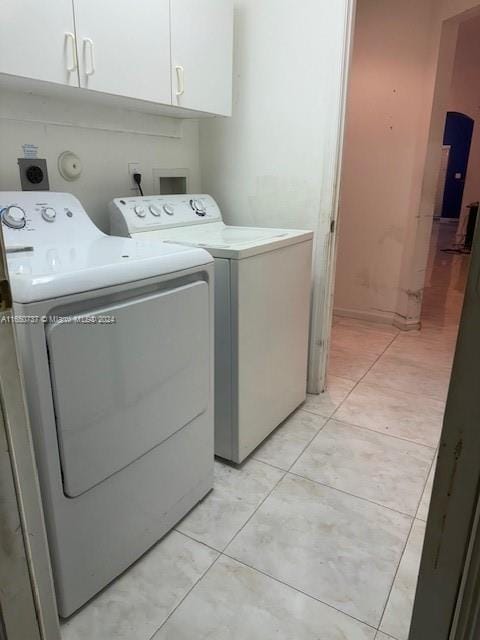 washroom featuring light tile patterned floors, cabinet space, and independent washer and dryer