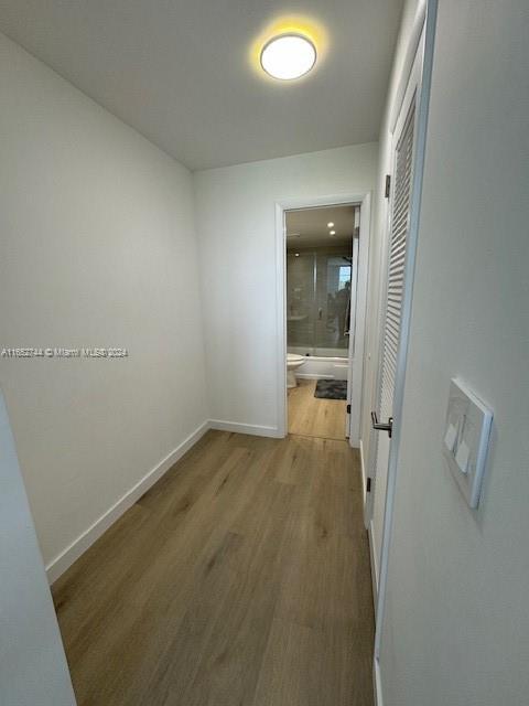 hallway with hardwood / wood-style flooring