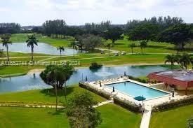 view of swimming pool with a yard and a water view