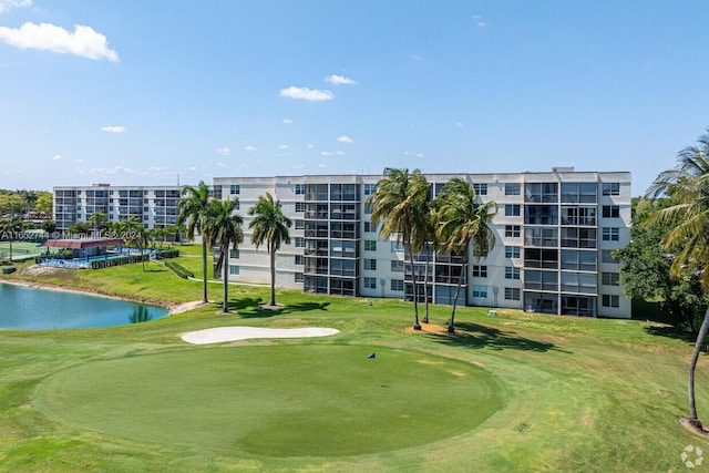 view of property's community featuring a lawn and a water view