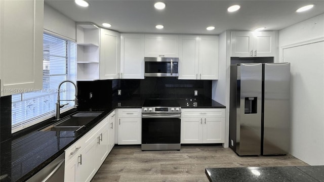 kitchen featuring sink, white cabinetry, light hardwood / wood-style flooring, and stainless steel appliances