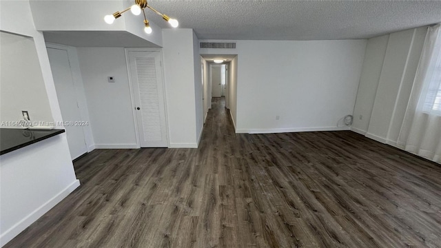 interior space featuring a chandelier, a textured ceiling, and dark hardwood / wood-style flooring