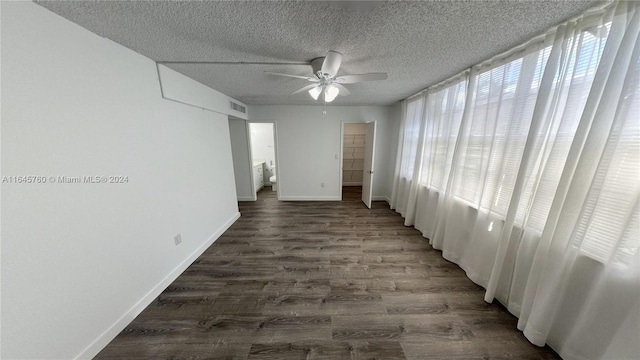 spare room featuring dark hardwood / wood-style floors, a textured ceiling, and ceiling fan