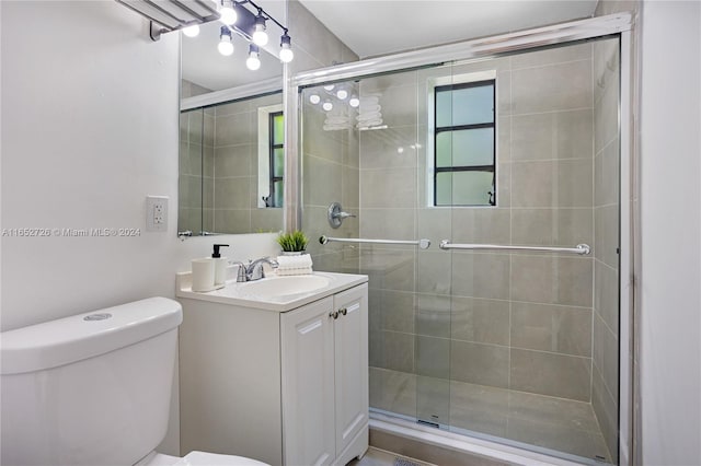 bathroom featuring a shower stall, toilet, and vanity