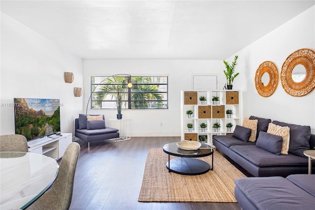 living area featuring baseboards and dark wood-style flooring