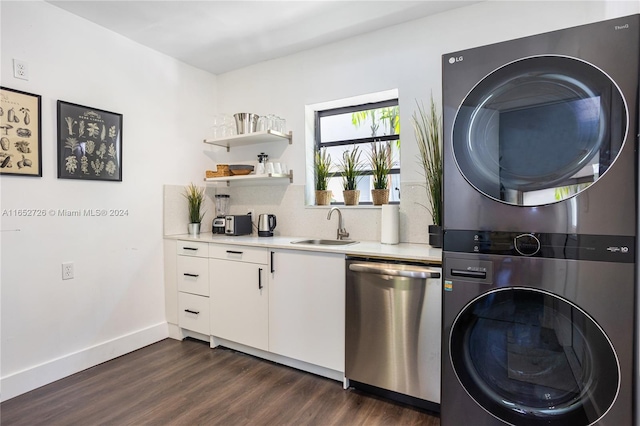 washroom featuring baseboards, laundry area, a sink, dark wood-type flooring, and stacked washer and dryer