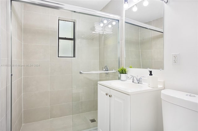 full bath with vanity, a shower stall, and toilet