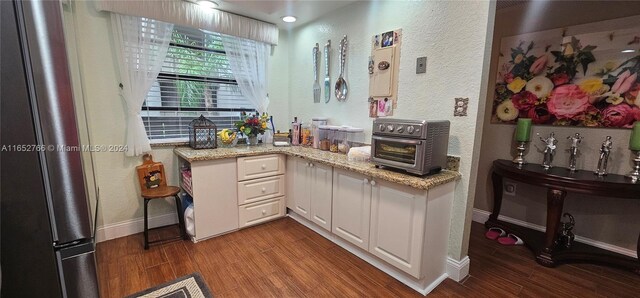 kitchen featuring white cabinetry, wood-type flooring, and light stone countertops