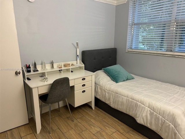 bedroom with light hardwood / wood-style floors and ornamental molding