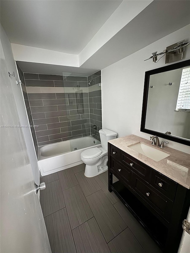 full bathroom with tiled shower / bath, vanity, and toilet