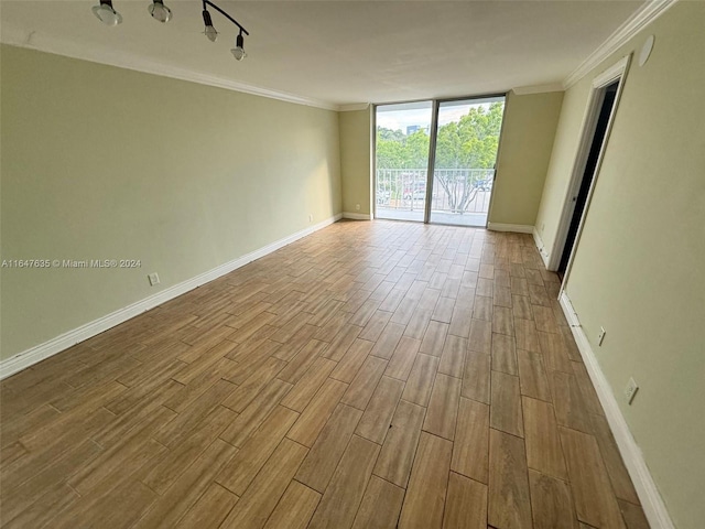 unfurnished room featuring ornamental molding and light hardwood / wood-style floors