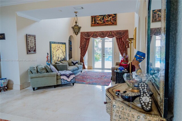 living room with arched walkways, french doors, crown molding, visible vents, and baseboards