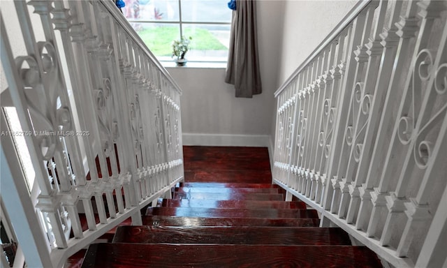 stairway featuring wood finished floors and baseboards