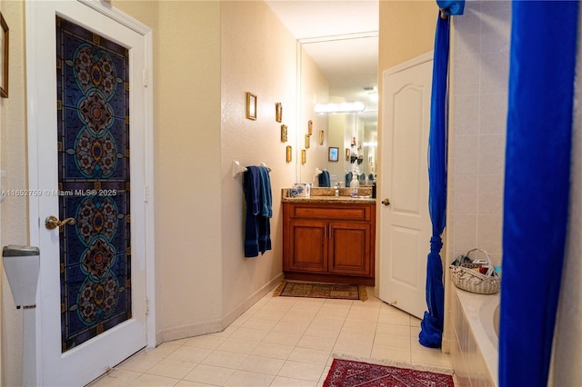 full bath with a washtub, vanity, baseboards, a shower, and tile patterned floors