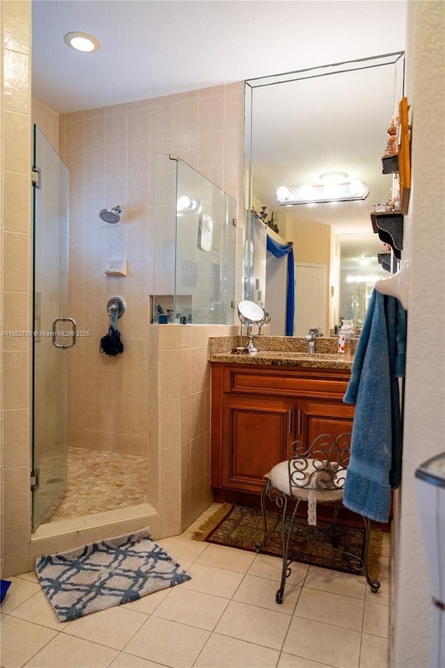 full bathroom featuring a stall shower, tile patterned flooring, and vanity