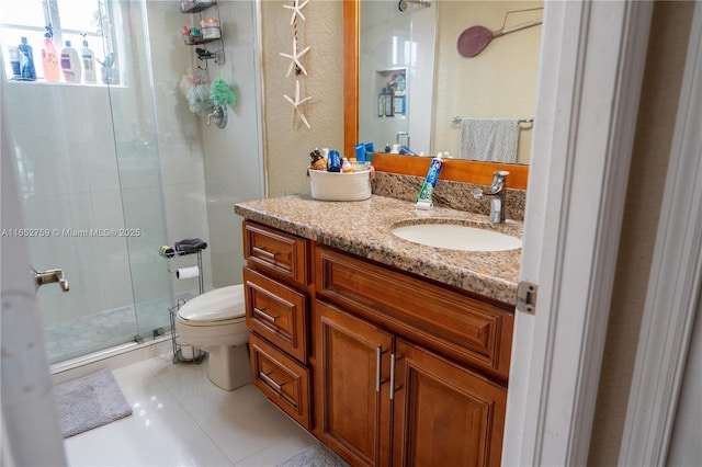 bathroom featuring a stall shower, vanity, toilet, and tile patterned floors