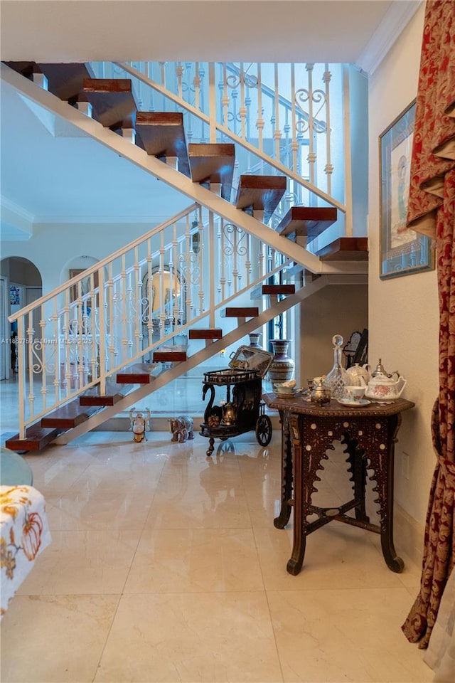 stairway with ornamental molding and arched walkways