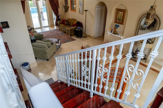 staircase with french doors, tile patterned flooring, and baseboards