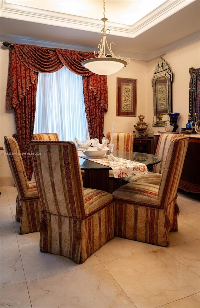 dining area with ornamental molding, a raised ceiling, and marble finish floor