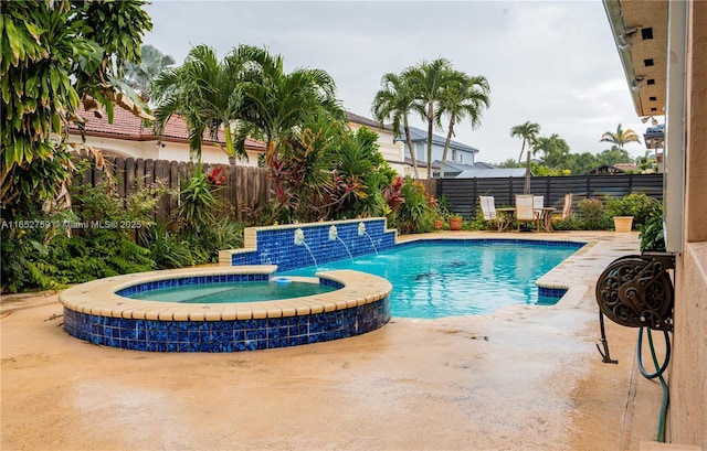 view of swimming pool with a patio area, a fenced backyard, and a pool with connected hot tub