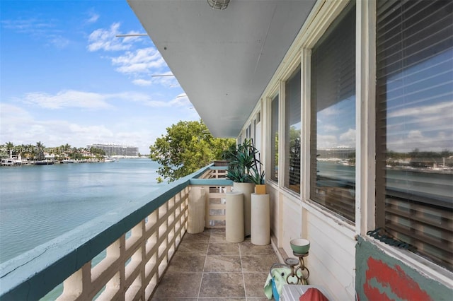 balcony featuring a sunroom and a water view